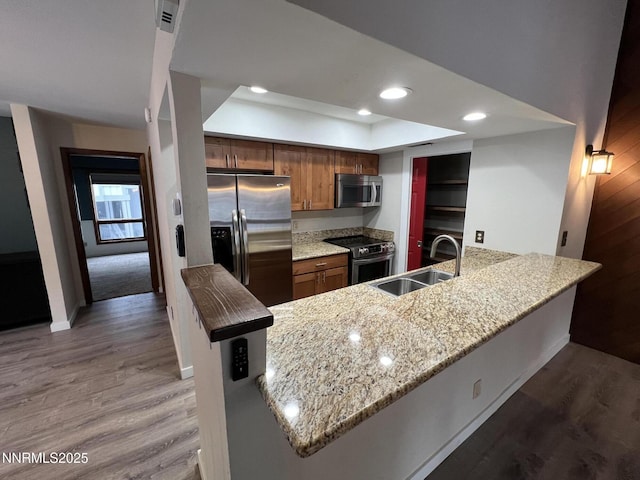 908 Harold Dr Unit 23, Incline Village, NV 89451 - kitchen with appliances with stainless steel finishes, a peninsula, wood finished floors, recessed lighting, and light stone countertops