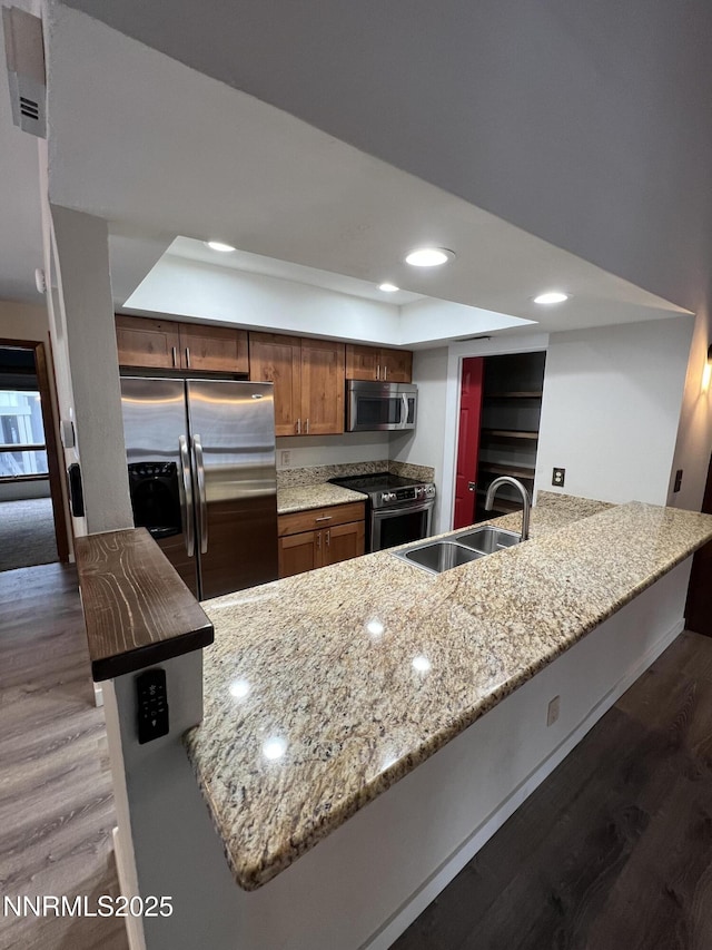 908 Harold Dr Unit 23, Incline Village, NV 89451 - kitchen featuring stainless steel appliances, a peninsula, dark wood-type flooring, light stone counters, and recessed lighting