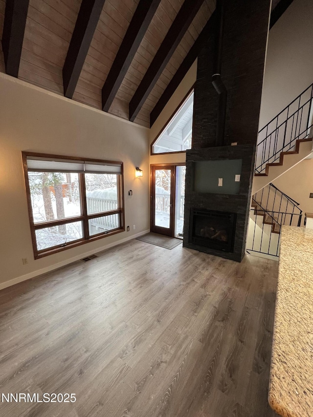 908 Harold Dr Unit 23, Incline Village, NV 89451 - unfurnished living room featuring high vaulted ceiling, a wood ceiling with exposed beams, stairway, wood finished floors, and a fireplace