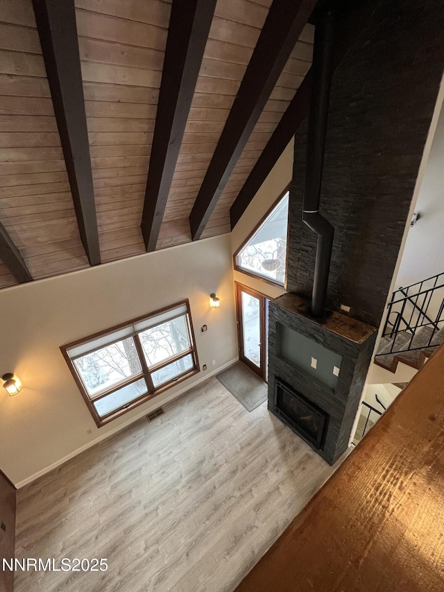 908 Harold Dr Unit 23, Incline Village, NV 89451 - unfurnished living room with plenty of natural light, a wood stove, beam ceiling, wood finished floors, and high vaulted ceiling