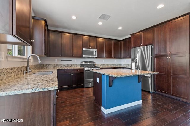 2720 Peavine Pines Ct, Reno, NV 89523 - kitchen featuring appliances with stainless steel finishes, light stone countertops, a breakfast bar area, dark wood finished floors, and dark brown cabinets