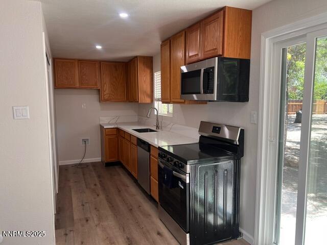 9180 Fremont Way, Reno, NV 89506 - kitchen featuring stainless steel appliances, brown cabinetry, light wood finished floors, light countertops, and recessed lighting