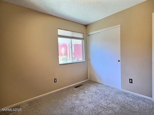 8425 Corrigan Way, Reno, NV 89506 - unfurnished bedroom with carpet floors, a textured ceiling, and a closet