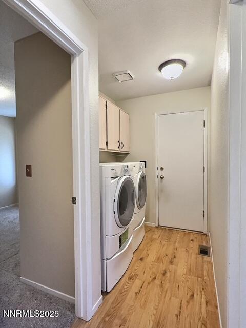 8425 Corrigan Way, Reno, NV 89506 - laundry room with washer and clothes dryer, cabinet space, and light wood-style flooring