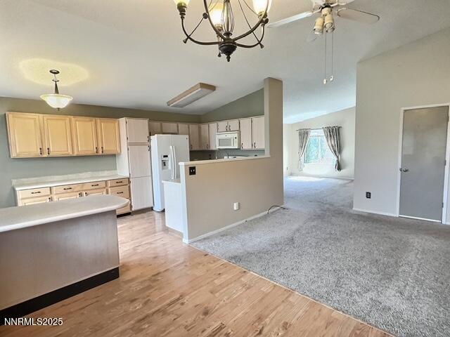 8425 Corrigan Way, Reno, NV 89506 - kitchen featuring white appliances, vaulted ceiling, hanging light fixtures, ceiling fan, and light countertops