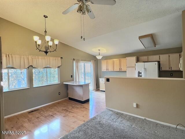 8425 Corrigan Way, Reno, NV 89506 - kitchen with white appliances, lofted ceiling, light wood-type flooring, pendant lighting, and ceiling fan