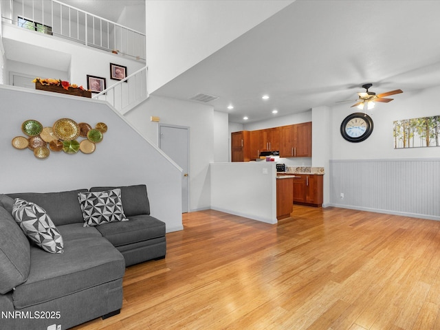 4325 Leeward Ln, Reno, NV 89502 - living area featuring light wood finished floors, stairway, recessed lighting, a ceiling fan, and wainscoting