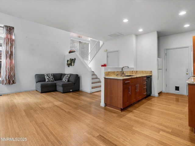 4325 Leeward Ln, Reno, NV 89502 - kitchen with light wood-style flooring, recessed lighting, light stone countertops, brown cabinets, and freestanding refrigerator