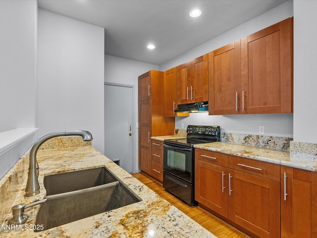 4325 Leeward Ln, Reno, NV 89502 - kitchen with black range with electric stovetop, light wood finished floors, light stone countertops, under cabinet range hood, and brown cabinets