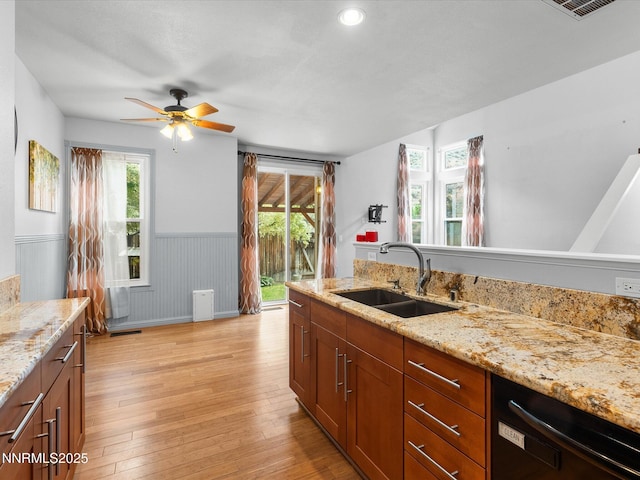 4325 Leeward Ln, Reno, NV 89502 - kitchen with dishwasher, wainscoting, a ceiling fan, light wood-style flooring, and light stone countertops