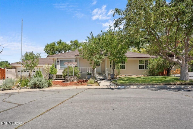 7 Circle Dr, Carson City, NV 89703 - view of front of home with a tile roof, stucco siding, covered porch, and a front yard