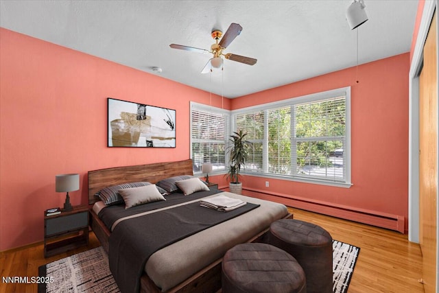 7 Circle Dr, Carson City, NV 89703 - bedroom featuring a baseboard heating unit, wood finished floors, and a ceiling fan