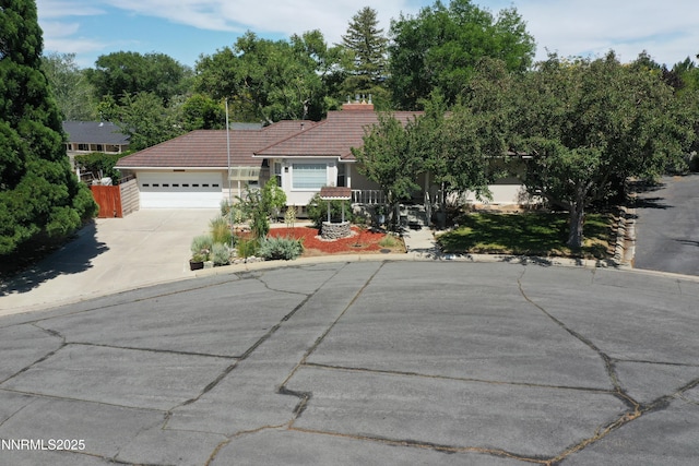 7 Circle Dr, Carson City, NV 89703 - view of front of home featuring a tile roof, concrete driveway, a garage, and stucco siding