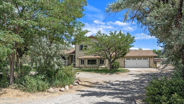 2450 Chukar Dr, Washoe Valley, NV 89704 - obstructed view of property featuring driveway, a garage, and stucco siding