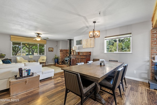 2450 Chukar Dr, Washoe Valley, NV 89704 - dining room with a wood stove, dark wood finished floors, plenty of natural light, and ceiling fan