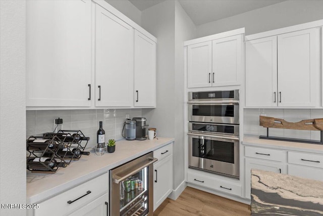 5517 Western Rider Trl, Reno, NV 89511 - kitchen with stainless steel double oven, wine cooler, tasteful backsplash, and white cabinets