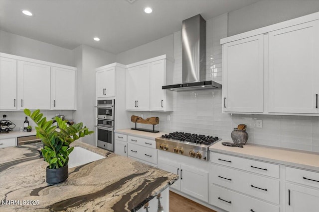 5517 Western Rider Trl, Reno, NV 89511 - kitchen with wall chimney exhaust hood, appliances with stainless steel finishes, white cabinets, tasteful backsplash, and recessed lighting