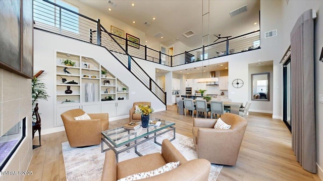 5517 Western Rider Trl, Reno, NV 89511 - living area with a towering ceiling, stairway, light wood-style flooring, and built in shelves
