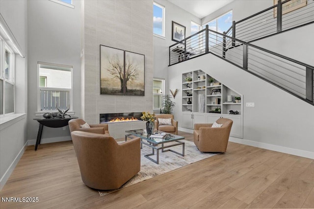 5517 Western Rider Trl, Reno, NV 89511 - living room featuring a high ceiling, a tile fireplace, stairway, wood finished floors, and built in shelves