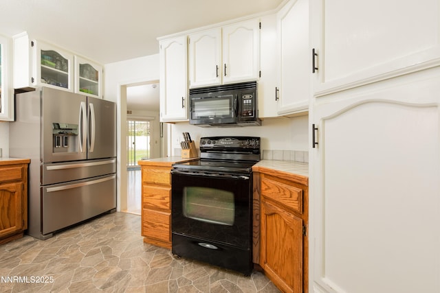 653 Carmel Way, Gardnerville, NV 89460 - kitchen featuring black appliances, tile counters, light stone finish flooring, and white cabinetry