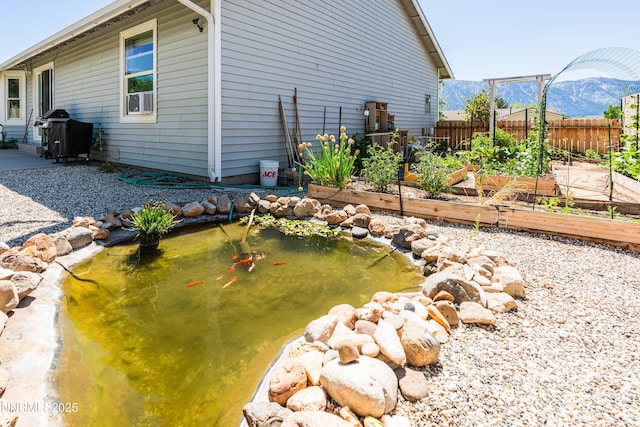 653 Carmel Way, Gardnerville, NV 89460 - view of side of property featuring a garden, a garden pond, a mountain view, and cooling unit