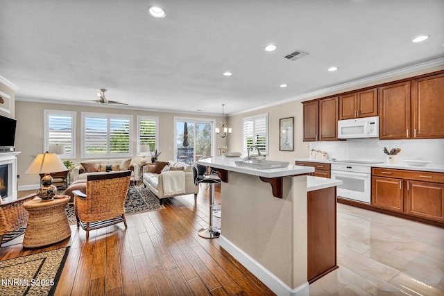 3579 Long Dr, Minden, NV 89423 - kitchen with white appliances, crown molding, a kitchen bar, light countertops, and open floor plan
