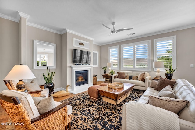 3579 Long Dr, Minden, NV 89423 - living area with wood finished floors, plenty of natural light, ornamental molding, a glass covered fireplace, and a ceiling fan