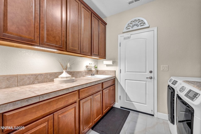 3579 Long Dr, Minden, NV 89423 - laundry room featuring independent washer and dryer, cabinet space, light marble finish floors, and a textured wall