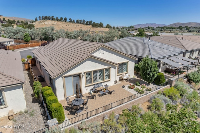 3579 Long Dr, Minden, NV 89423 - back of property with a fenced backyard, stucco siding, a tiled roof, a mountain view, and a patio area
