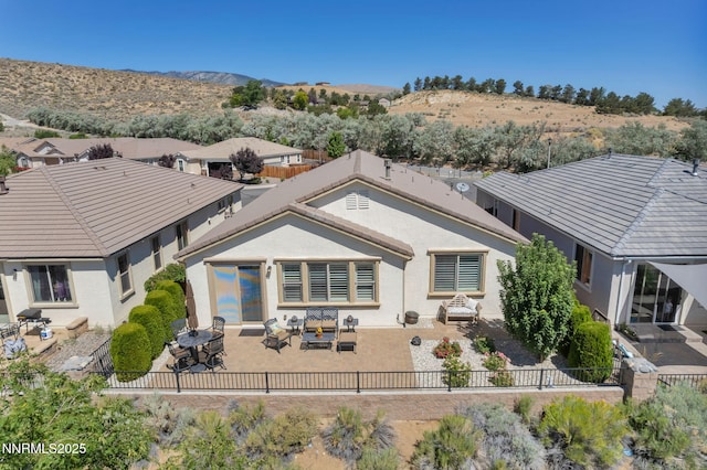 3579 Long Dr, Minden, NV 89423 - back of property featuring stucco siding, a patio, a fenced backyard, outdoor dining area, and a mountain view