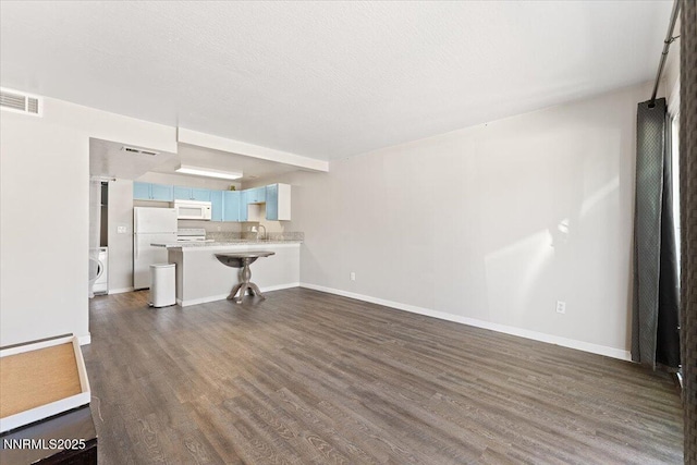 2555 Clear Acre Ln Apt 13, Reno, NV 89512 - unfurnished living room with dark wood-style floors and washer / dryer