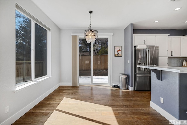 1585 Foster Dr, Reno, NV 89509 - kitchen with stainless steel refrigerator with ice dispenser, healthy amount of natural light, a chandelier, white cabinets, and recessed lighting