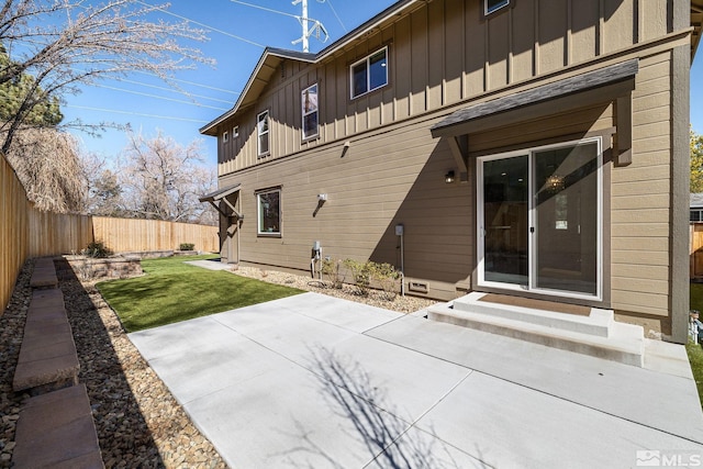 1585 Foster Dr, Reno, NV 89509 - back of property with board and batten siding, entry steps, a fenced backyard, and a patio area