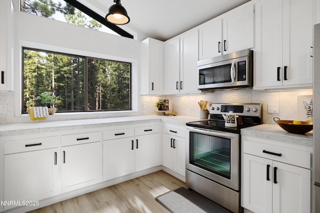 960 Apollo Way, Incline Village, NV 89451 - kitchen with stainless steel appliances, decorative backsplash, white cabinets, and light wood finished floors