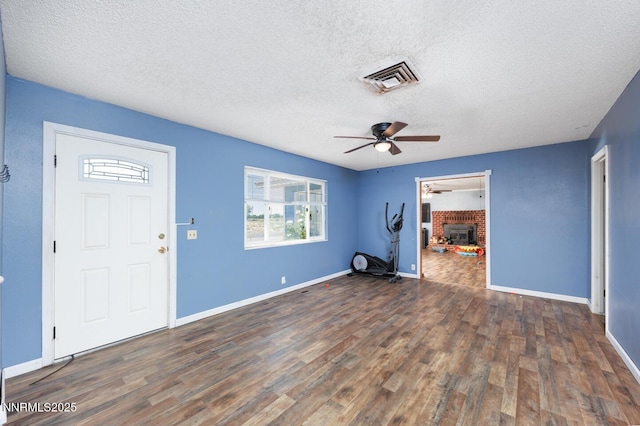 3480 York Ln, Fallon, NV 89406 - unfurnished living room featuring wood finished floors, a textured ceiling, a ceiling fan, and a fireplace