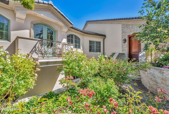 3820 Frost Ln, Reno, NV 89511 - view of exterior entry featuring stone siding, stucco siding, a balcony, and a tile roof
