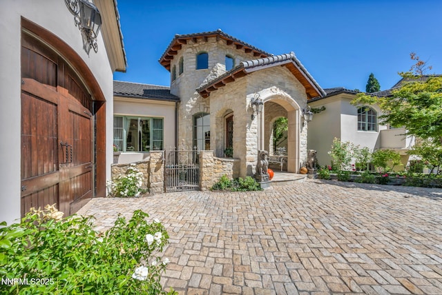 3820 Frost Ln, Reno, NV 89511 - mediterranean / spanish home featuring stone siding, a gate, a tiled roof, and stucco siding