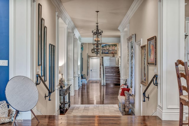 3820 Frost Ln, Reno, NV 89511 - entryway with crown molding, wood finished floors, a chandelier, decorative columns, and stairs
