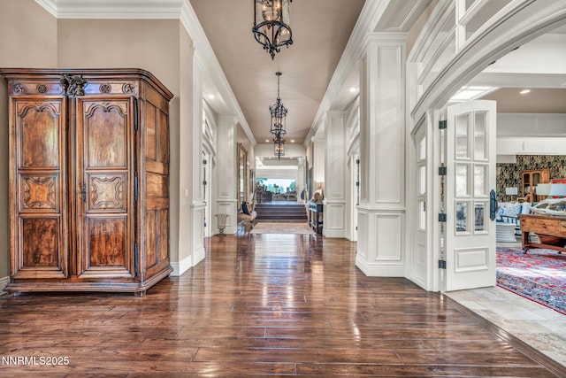 3820 Frost Ln, Reno, NV 89511 - foyer featuring dark wood-style floors, crown molding, arched walkways, and a chandelier