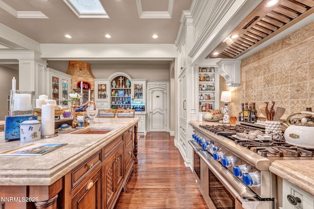 3820 Frost Ln, Reno, NV 89511 - kitchen with brown cabinets, range with two ovens, light countertops, wood finished floors, and custom exhaust hood