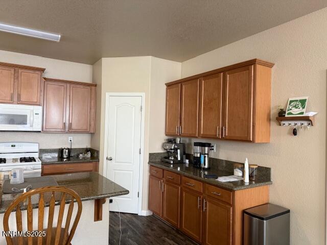 1108 Tuscan Ct, Minden, NV 89423 - kitchen featuring white microwave, range, and brown cabinetry