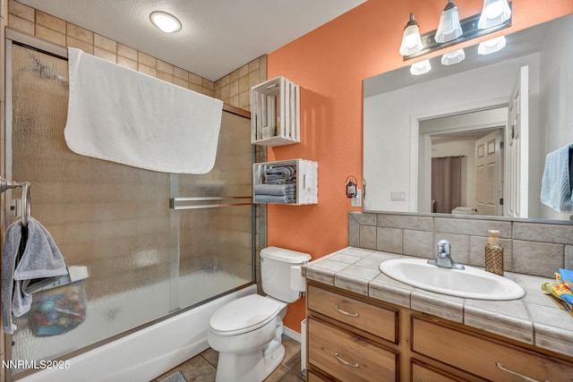 8030 Verde Ct, Winnemucca, NV 89445 - bathroom with vanity, bath / shower combo with glass door, tile patterned flooring, and tasteful backsplash