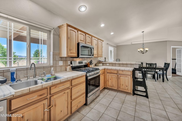 8030 Verde Ct, Winnemucca, NV 89445 - kitchen with appliances with stainless steel finishes, tile countertops, backsplash, a chandelier, and lofted ceiling