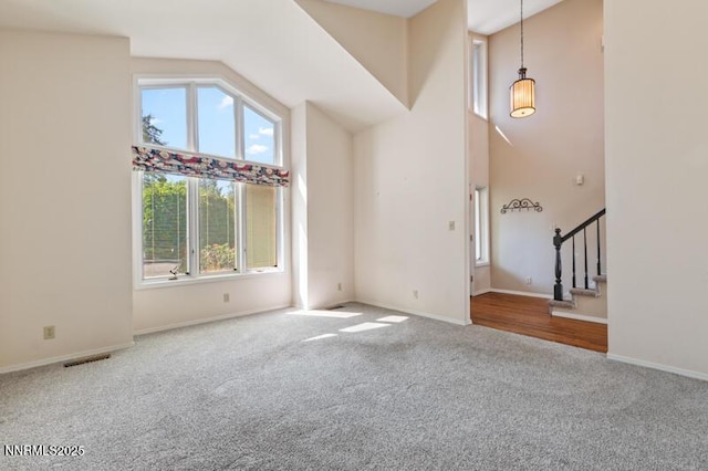 2126 Thomas Jefferson Dr, Reno, NV 89509 - unfurnished living room featuring carpet, stairway, and high vaulted ceiling