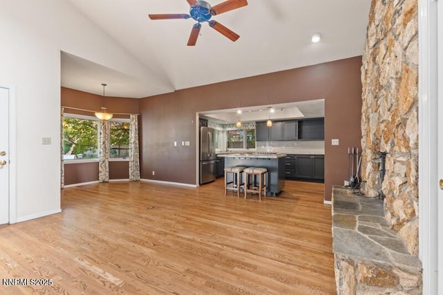 2126 Thomas Jefferson Dr, Reno, NV 89509 - unfurnished living room with light wood-style flooring, a ceiling fan, and vaulted ceiling