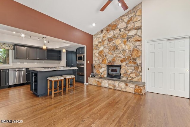 2126 Thomas Jefferson Dr, Reno, NV 89509 - kitchen featuring stainless steel appliances, a center island, a kitchen bar, wood finished floors, and light countertops