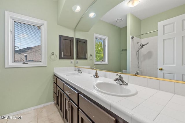 2126 Thomas Jefferson Dr, Reno, NV 89509 - bathroom featuring double vanity, a tile shower, and tile patterned flooring