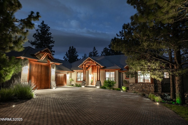 48 Rose Creek Ln, Reno, NV 89511 - view of front of home featuring stone siding, an attached garage, stucco siding, and decorative driveway