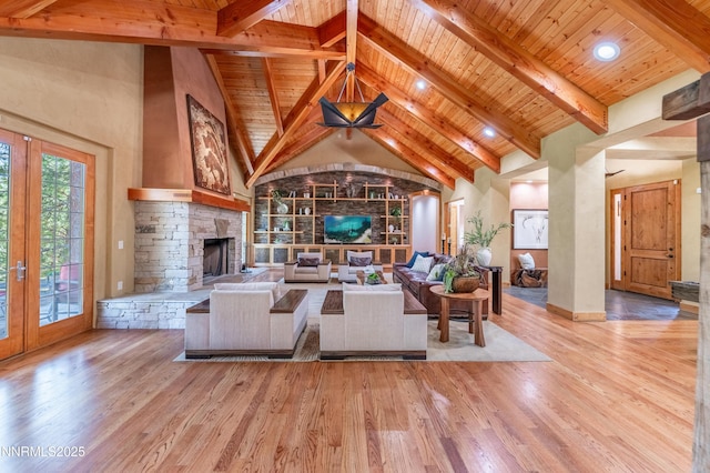 48 Rose Creek Ln, Reno, NV 89511 - living room featuring a wooden ceiling with exposed beams, a stone fireplace, wood finished floors, high vaulted ceiling, and french doors