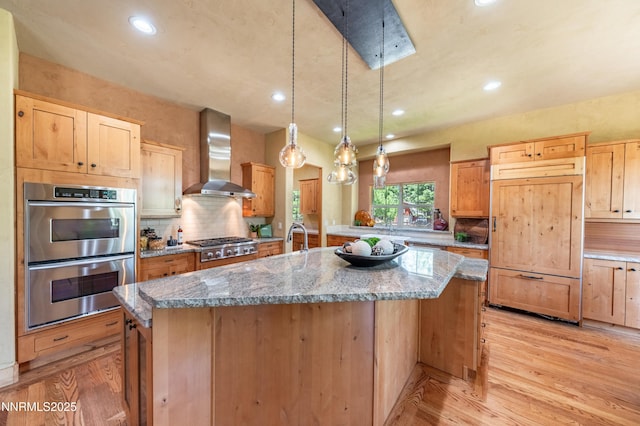 48 Rose Creek Ln, Reno, NV 89511 - kitchen with wall chimney exhaust hood, stainless steel appliances, light wood-style flooring, an island with sink, and decorative backsplash
